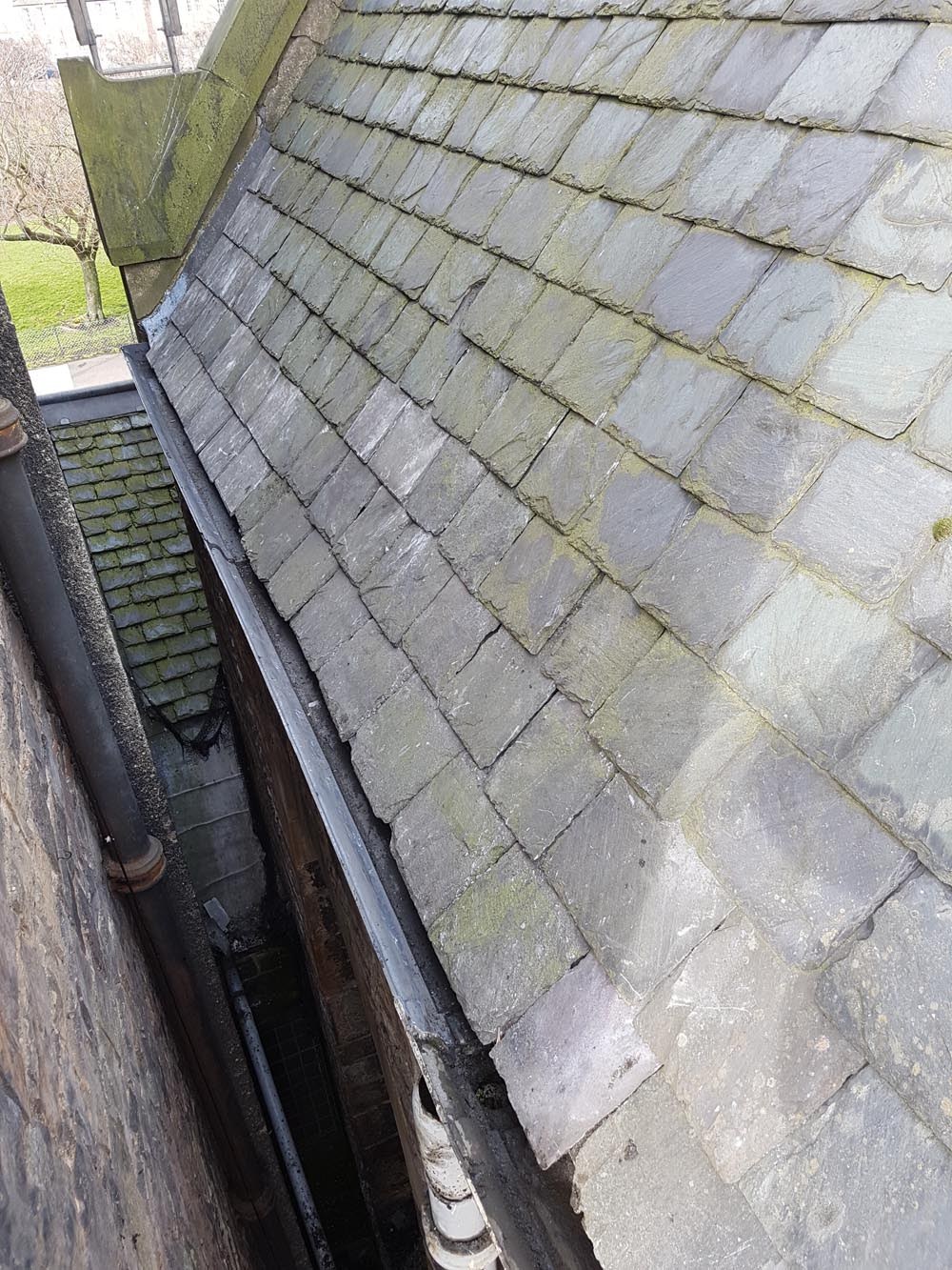 Looking along the newly fitted gutters with all the slates patched back in